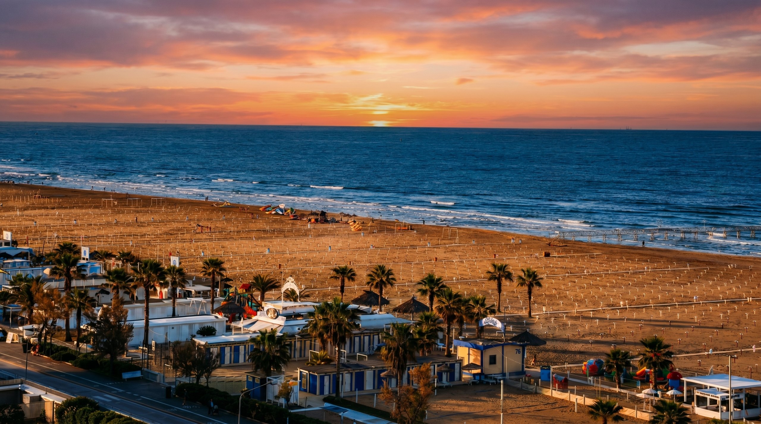 Vista panoramica della spiaggia di Rimini al tramonto, con il lungomare alberato di palme e il mare Adriatico