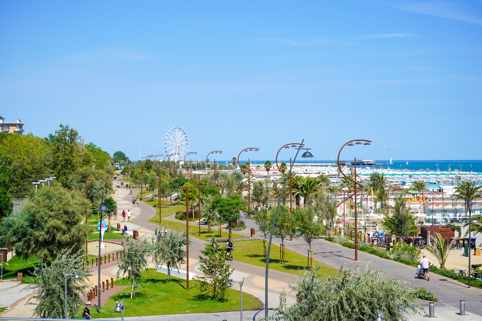 Il nuovo lungomare di Rimini Marina Centro — passeggiata pedonale, ruota panoramica, palme e spiaggia con vista sull'Adriatico