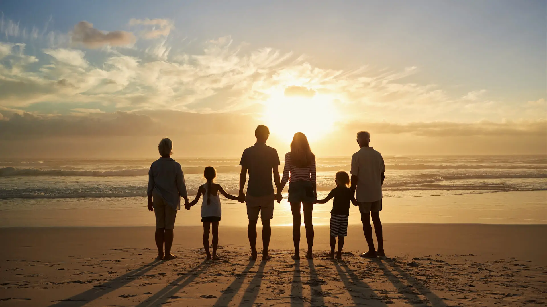 Una famiglia di tre generazioni mano nella mano davanti all'Adriatico al tramonto — l'esperienza che vogliamo regalare a ogni ospite dell'Hotel Columbia